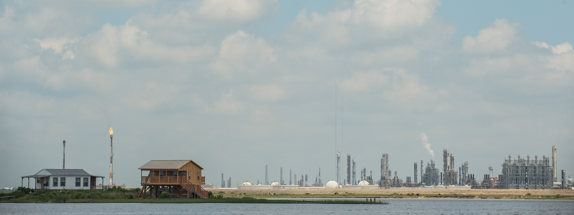Homes in front of an oil refinery across the water