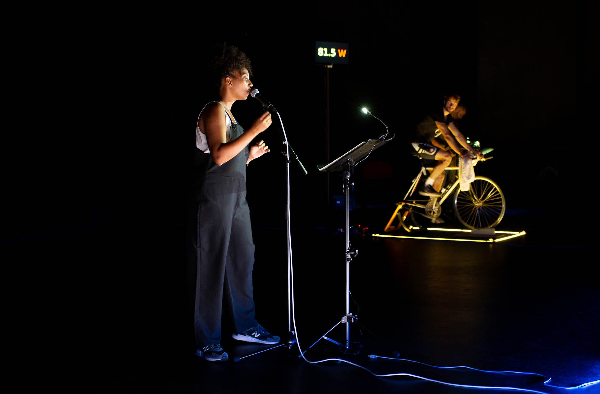 Performers on a dark stage in the spotlight